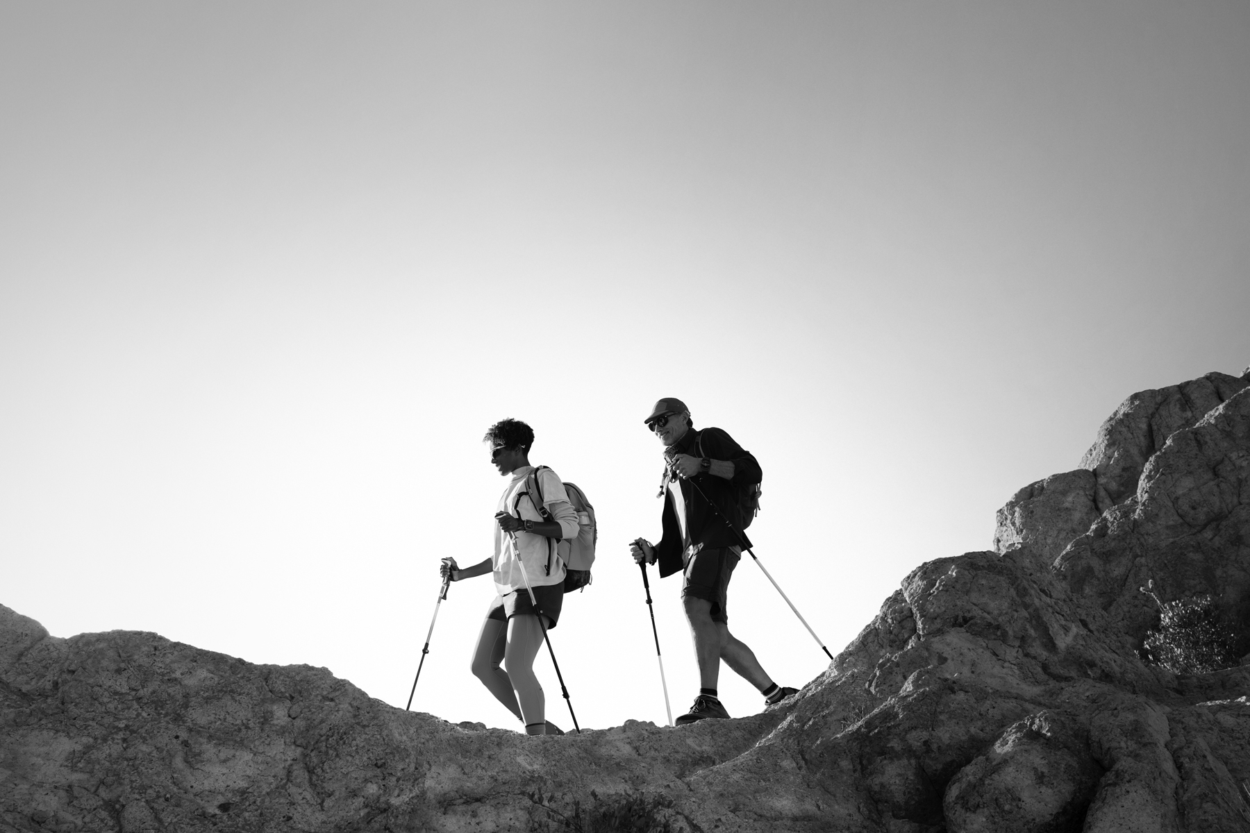 Deux personnes portant des Apple Watch Ultra 3 en randonnée sur un sentier montagneux