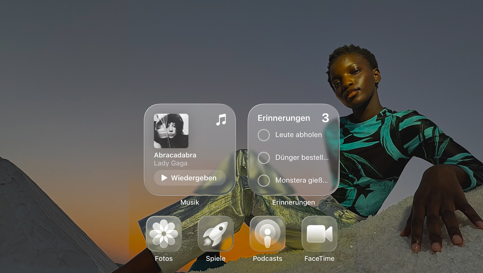 Liquid Glass Display mit transparenten App Symbolen für Apple Music, Erinnerungen, Fotos, Spiele, Podcasts und FaceTime, die das Hintergrundbild reflektieren