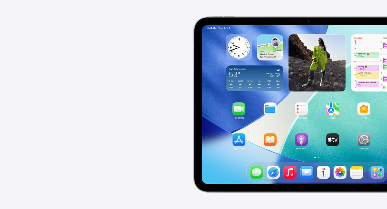 iPad vaaka-asennossa, vain näytön vasen puoli. Koti-valikossa on päällekkäin olevia widgettejä, mukaan lukien läpikuultava kello Liquid Glass ‑ulkoasulla, Etsi-appi, Sää-widgetti, kaksi riviä pienempiä appeja ja Dock
