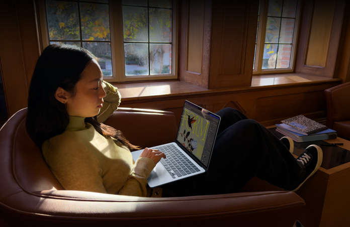 En person sidder på en stol og bruger en MacBook Air